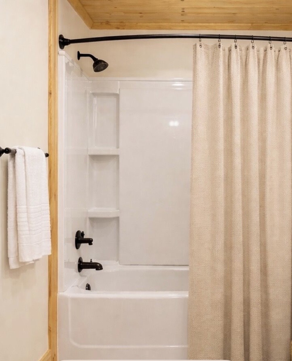 Bathroom with tub-shower combo and dark hardware