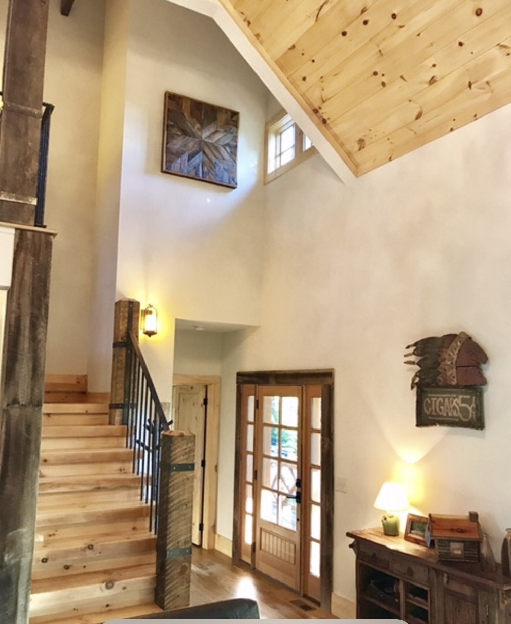 Entry with vaulted ceiling and timber-wrapped staircase
