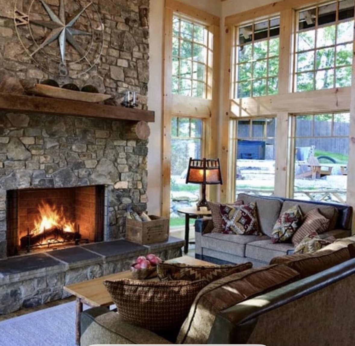 Living room with a lit stone fireplace and cozy seating