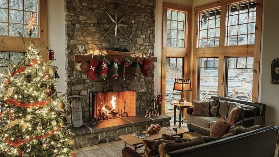 Living room with stone wood-burning fireplace and vaulted ceiling