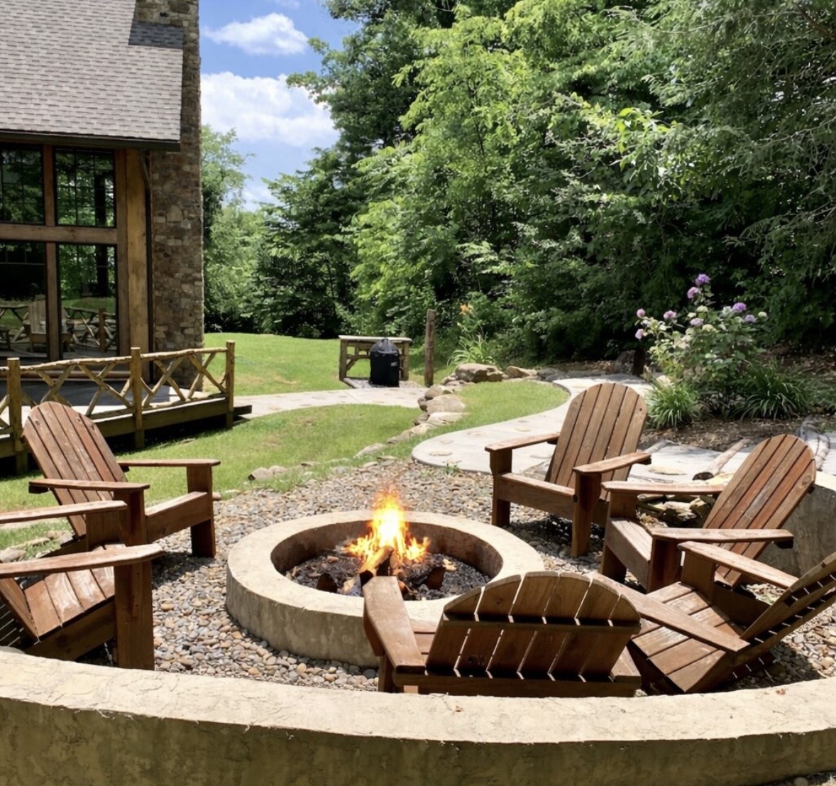 Outdoor fire pit with Adirondack chairs and garden path