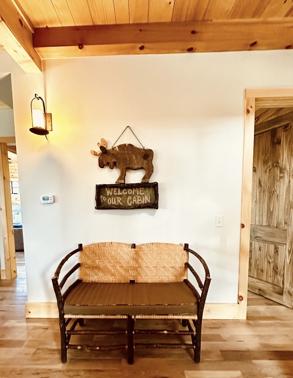 Entryway with moose sign and woven bench