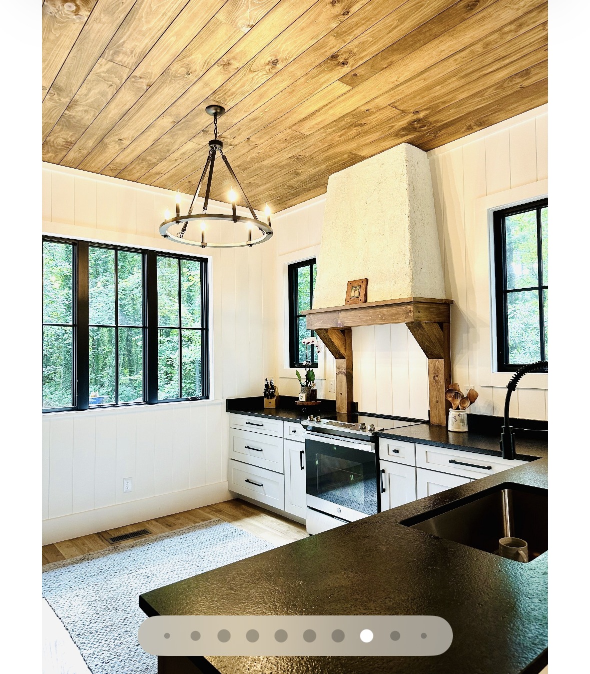 Kitchen with black countertops and a plaster range hood