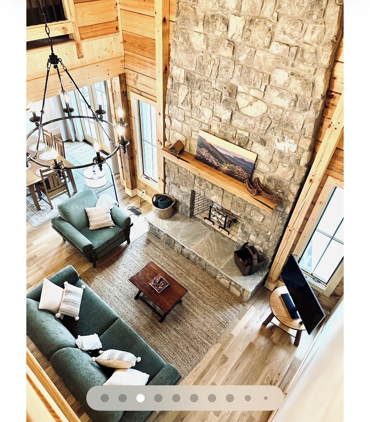 Living room with soaring stone fireplace and vaulted wood ceiling