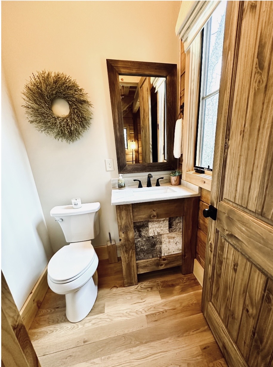 Powder room with dried wreath and wood vanity